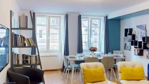 a dining room with a table with yellow chairs at COLMARAPPART Grand'Rue in Colmar
