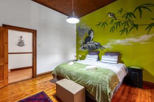 a bedroom with a bed with a painting on the wall at Emma's Place in De Rust