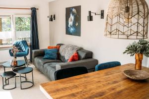 a living room with a couch and a table at Forrest Lodge in bosrijke omgeving de Veluwe - met terras, tuin en fietsschuurtje in Nunspeet