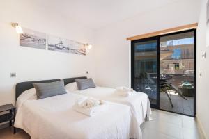 two beds in a room with a window at Parque Atlântico Apartment in Quarteira +17 photos