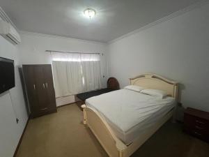 a bedroom with a white bed and a window at Pousada central in Sinop +4 photos