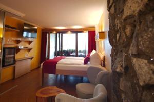 a hotel room with a bed and a large window at BoutiqueHotel KAPUZINERGARTEN in Breisach am Rhein