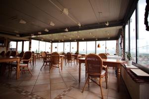 a restaurant with wooden tables and chairs and windows at BoutiqueHotel KAPUZINERGARTEN in Breisach am Rhein