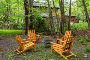 three wooden chairs and a fire pit in a yard at Sasquatch Hideaway Game Room Fire Pit in Mushroom Farms