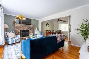 a living room with a blue couch and a fireplace at Sasquatch Hideaway Game Room Fire Pit in Mushroom Farms
