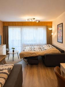 a hotel room with a bed and a couch at Mountain Holiday Leukerbad Free Parking and WiFi Playroom 96 in Leukerbad