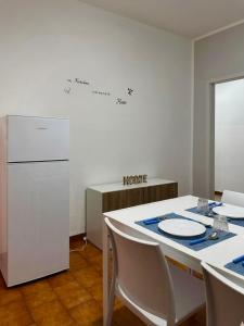 a kitchen with a white table and a refrigerator at Casa Tropea Vibes in Tropea