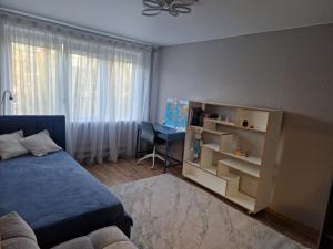 a bedroom with a blue bed and a desk at Cozy 3 room appartment in Klaipėda