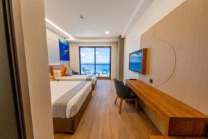 a hotel room with two beds and a desk and a window at Triton Exotica in Maafushi