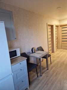 a small kitchen with a table and a microwave at Cozy 3 room appartment in Klaipėda