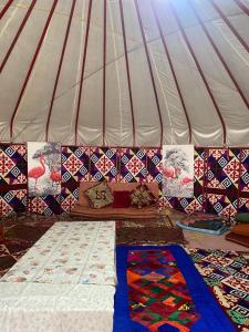 a tent with blankets and pillows on the ground at Murat Lyazzat Hotel in Kurmenty