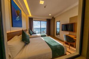 a hotel room with two beds and a television at Triton Exotica in Maafushi +104 photos