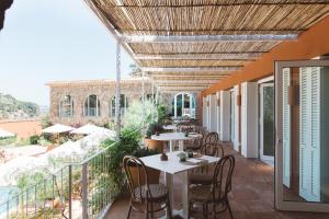 a restaurant with tables and chairs on a balcony at Finca Victoria, a Member of Design Hotels in Begur +52 photos