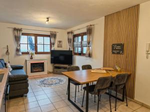 a living room with a table and a tv at Ferienwohnung Look wide in Oberelsbach