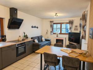 a kitchen and living room with a table and a couch at Ferienwohnung Look wide in Oberelsbach