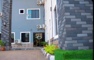 a blue building with plants in front of it at Jiksonodohotel in Nsukka