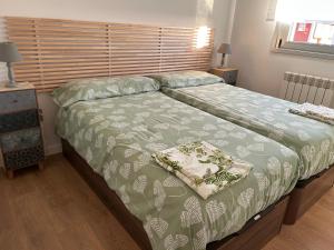 a bedroom with a bed with a green comforter at TÍA NANDUCA in Liencres