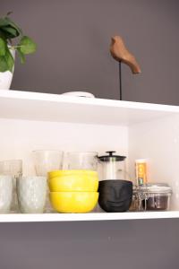 a shelf with bowls and other kitchen items on it at Liepaja Garden Studio with Terrace in Liepāja