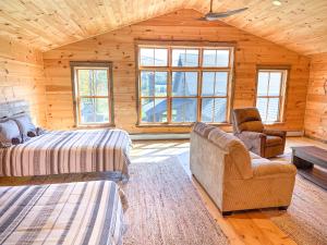 a log cabin bedroom with two beds and a chair at The Vines in Warren +70 photos