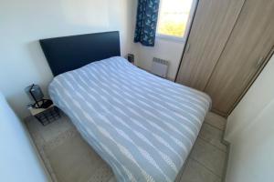 a small bed in a small room with a window at comfort and breathtaking view in Frontignan