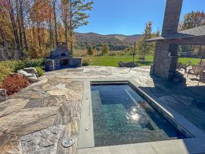 a swimming pool with a fireplace in a yard at The Vines in Warren