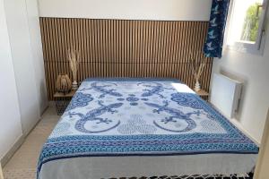a bed with a blue and white blanket on it at comfort and breathtaking view in Frontignan