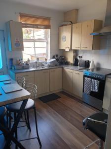 a kitchen with a table and a stove top oven at Miner's Retreat Comfy 2-Bed Home, Swadlincote in Woodville