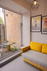 a living room with a couch and a table and a window at Liepaja Garden Studio with Terrace in Liepāja