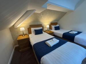 a hotel room with two beds and two lamps at Trivelles Belforte Hotel , Sale, Manchester - M33 2AE in Sale