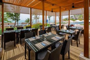 a restaurant with tables and chairs on a patio at The Ritz-Carlton, Koh Samui in Choeng Mon Beach