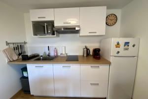 a kitchen with white cabinets and a white refrigerator at Hulot-838-Iodine parenthesis in Frontignan