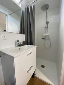 a white bathroom with a sink and a shower at Hulot-838-Iodine parenthesis in Frontignan +4 photos
