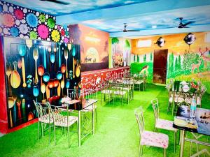 a dining room with tables and chairs and a mural at MAHAMAYA CONVENTION and HOTEL in Mālatīpātpur