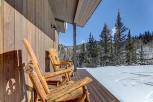 two rocking chairs sitting on a porch with snow at Mountain Escape with Spectacular Views in Jefferson