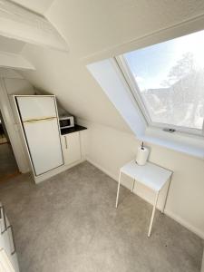 a small kitchen with a white refrigerator and a window at Bright and central city apartment near Aalborg Bus in Aalborg