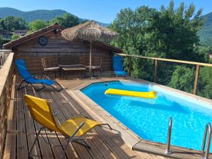 a pool on a deck with chairs and a table at Le Refuge De L'Ourse in Anla