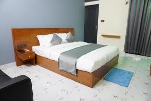 a bedroom with a large bed with a blue rug at Hotel Comfort Inn Sylhet in Sylhet