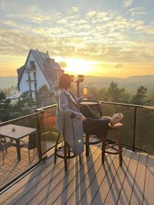 a woman sitting in a chair on a deck watching the sunset at Minnie Diamond in Divčibare