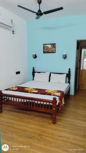 a bed in a room with a ceiling fan at The Haira Varkala in Varkala