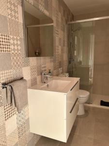 a bathroom with a white sink and a toilet at TÍA NANDUCA in Liencres