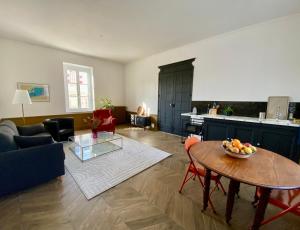 a living room with a table and a kitchen at Maison Loire et Mer in Mer