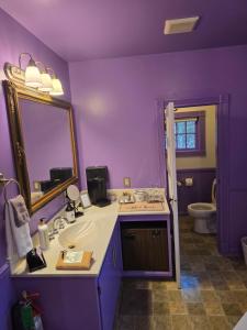 a purple bathroom with a sink and a mirror at Rock Cottage Gardens B&B in Eureka Springs +43 photos