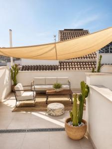 a patio with a couch and a table on a roof at Mariposa in Marbella