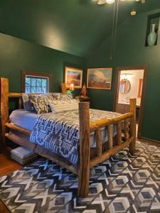 a bedroom with a wooden bed and green walls at Rock Cottage Gardens B&B in Eureka Springs
