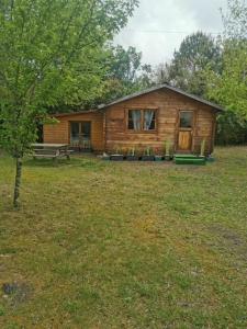 a log cabin with a bench in a yard at Chalet à Biscarrosse in Biscarrosse