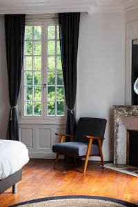 a bedroom with a chair and a window at Quatorze - manoir au coeur du parc du Château de La Garnache in La Garnache