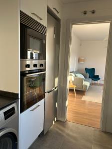 a kitchen with a stove top oven next to a living room at TÍA NANDUCA in Liencres +12 photos