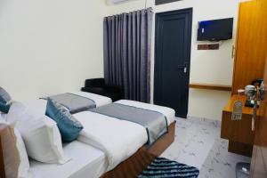 a hotel room with two beds and a tv at Hotel Comfort Inn Sylhet in Sylhet
