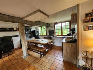 a large kitchen with a wooden table in it at Charming cottage in Boursay