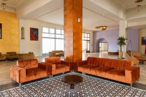 a lobby with brown leather couches and a table at Oasis Beach & Spa - Blue Pearl in Saïdia